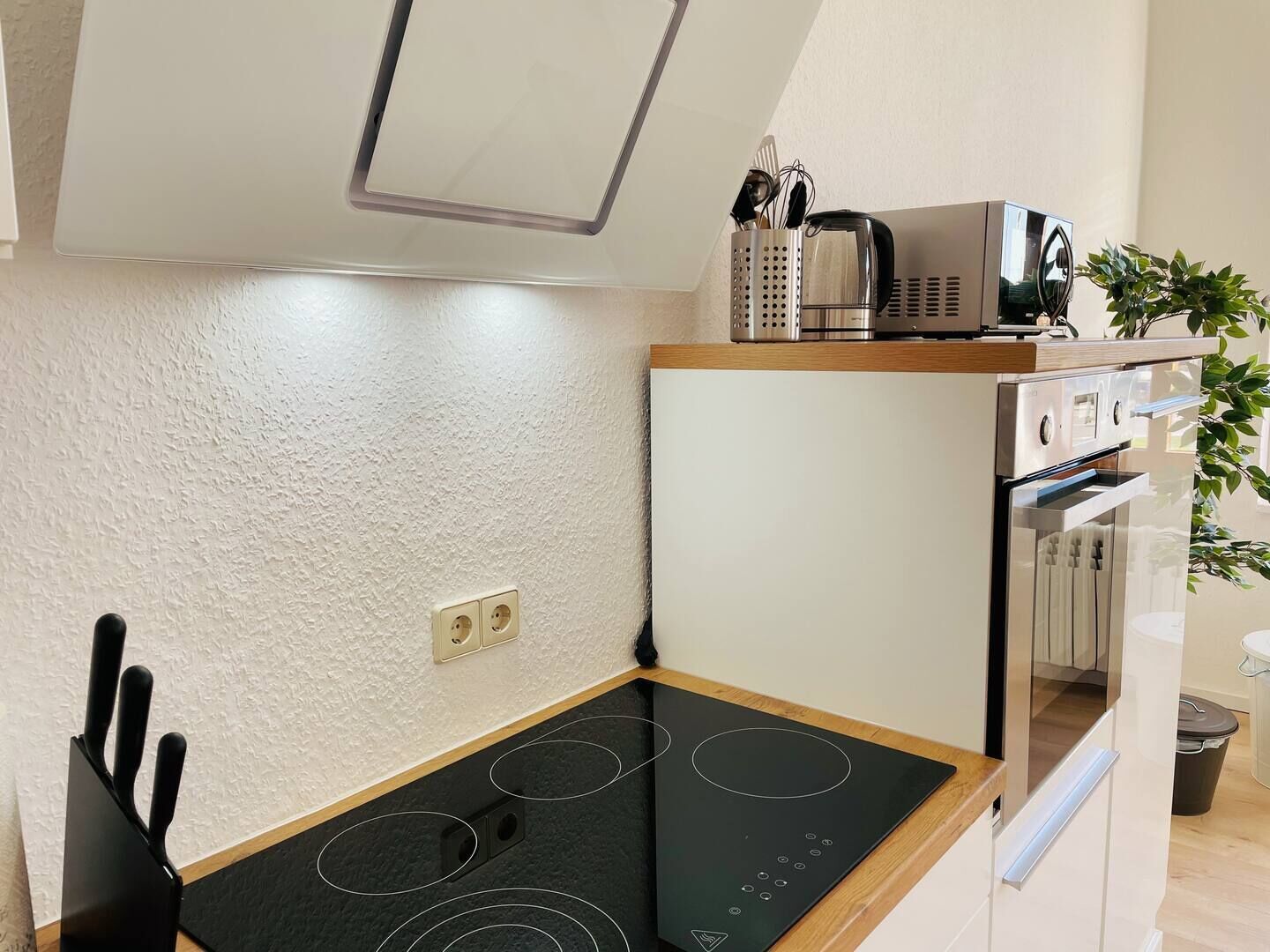 A compact kitchen with a built-in stove, microwave, and oven.
