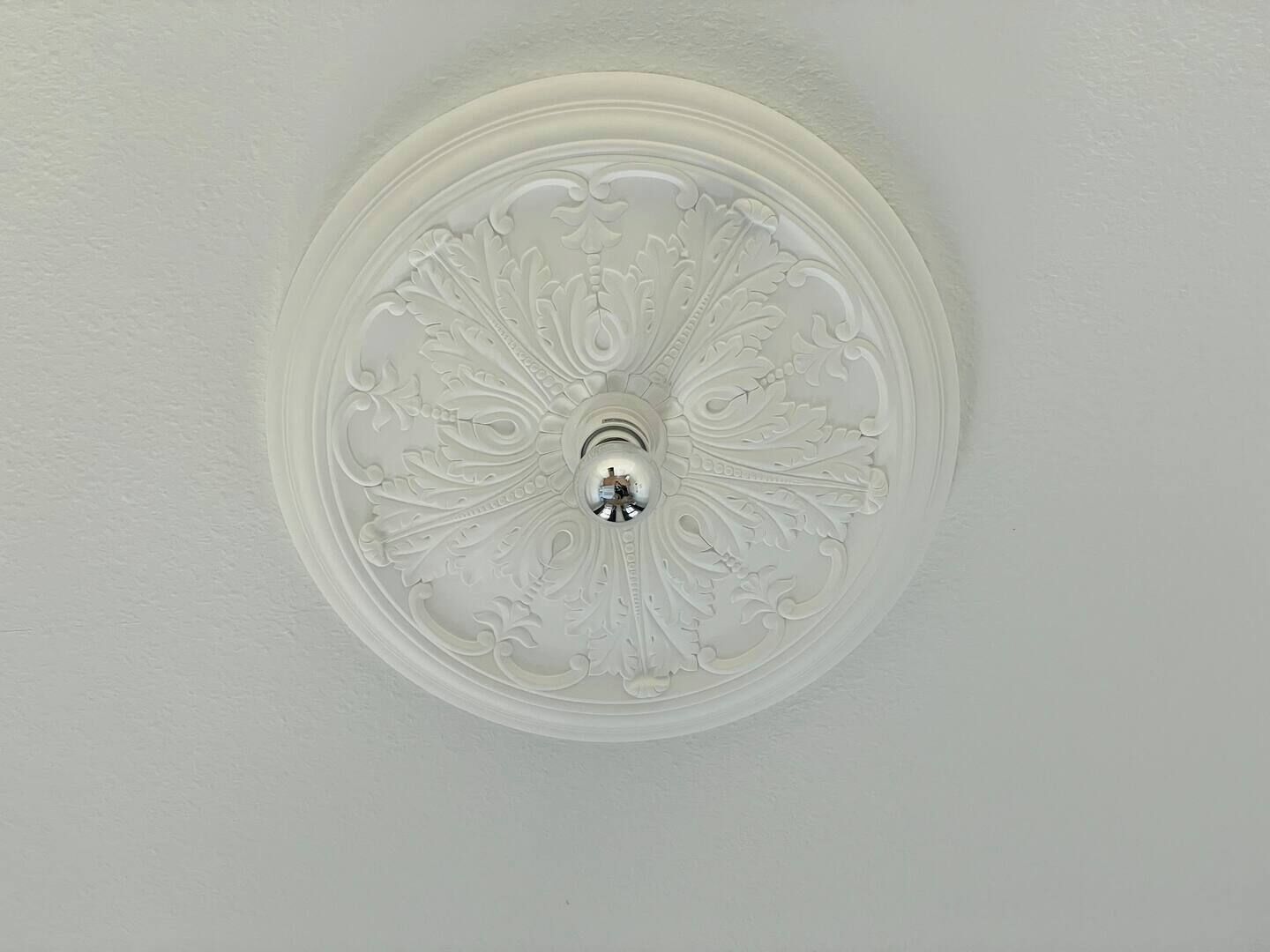 Un soffitto con un motivo decorativo circolare e rilievo.