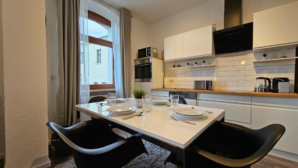 A compact kitchen with white cabinets, a microwave, and a coffee maker.