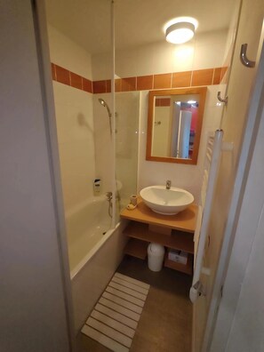 A bathroom with a bathtub, a sink, a mirror, and a shower. - Le Nid des Silènes – In the Heart of the Cimes 1800 (La Plagne Tarentaise)
