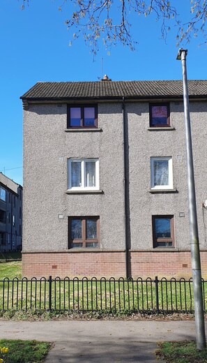 A multi-story building with a brick base and a textured facade, featuring multiple windows and a visible chimney. - 2BR- Modern, top floor apartment  -  Free parking fast internet.  Near hospitals (Aberdeen)