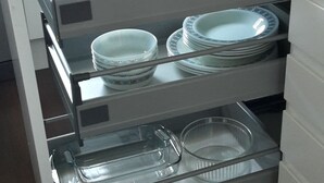 A kitchen with a built-in utensil drawer containing plates, bowls, and a glass container. - 2BR- Modern, top floor apartment  -  Free parking fast internet.  Near hospitals (Aberdeen)