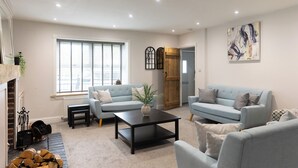A living room with two sofas, a coffee table, and a fireplace. - The Old Sawmill (Newcastle-upon-Tyne)