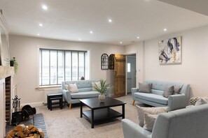 Ein Wohnzimmer mit zwei Sofas, einem Couchtisch und einem Kamin.