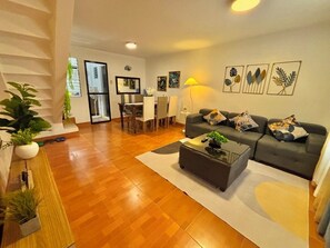 Una sala de estar moderna con un sofá, una mesa de centro y una zona de comedor.