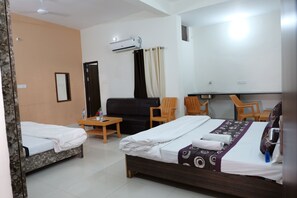 A hotel room with two beds, a sofa, a small table, and a chair. - Ramlalla Bhawan  (Ayodhya)