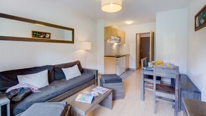 En moderne stue med sofa, sofabord og spiseplads med bord og stole.