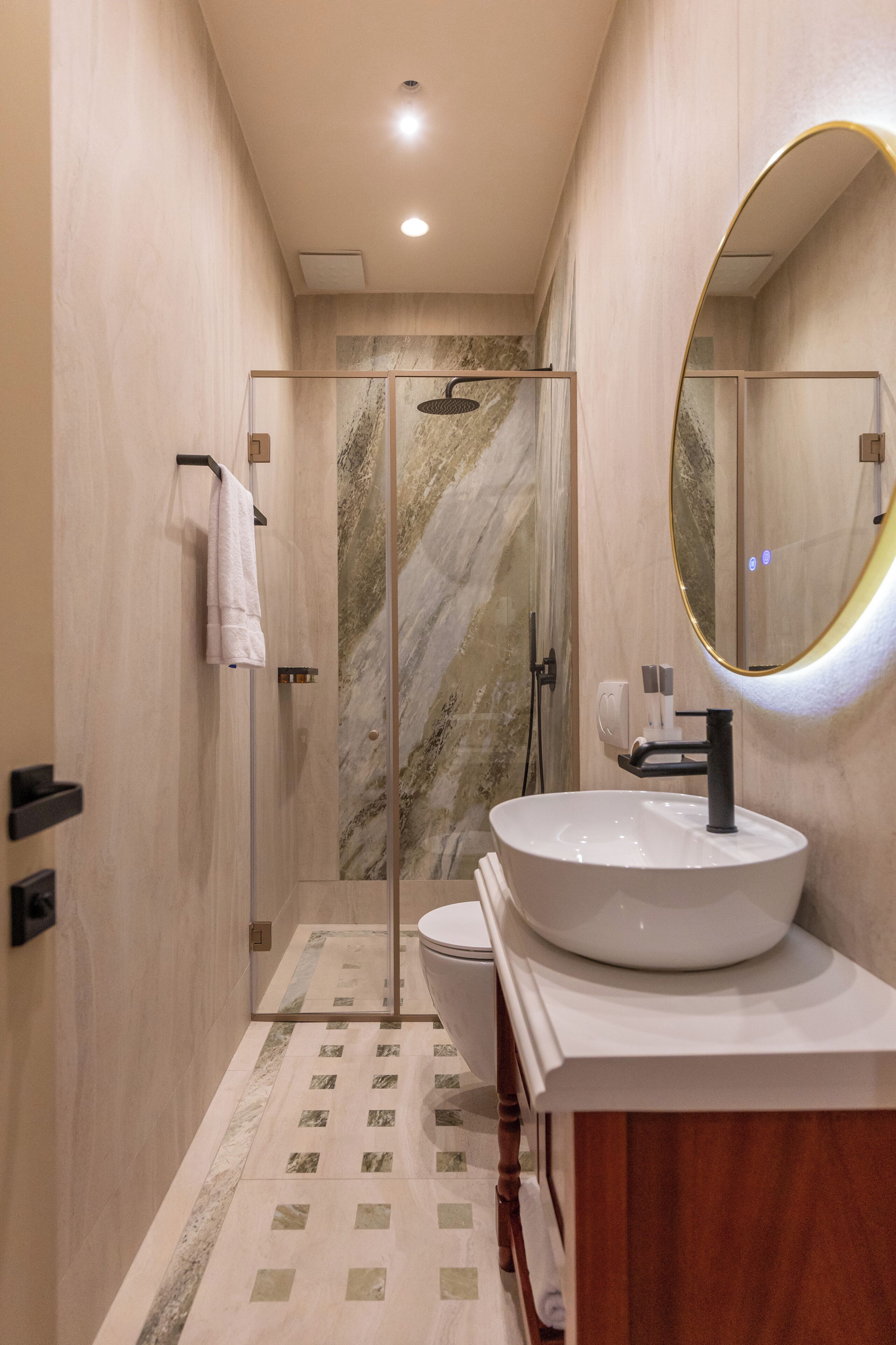 Un baño moderno con un espejo grande, un lavabo y una cabina de ducha.