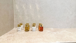 A row of four bottles of Laura Biagiotti ROMA products on a marble surface. - Vatër Hotel (Shkodër)