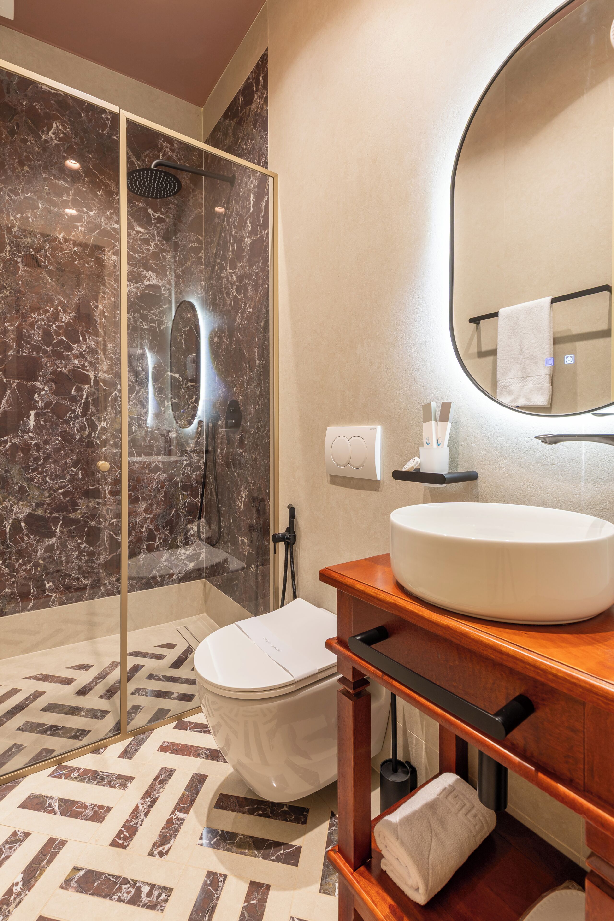 A modern bathroom with a glass-enclosed shower, a white sink, and a mirror above it.