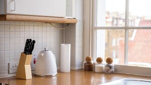 A kitchen with a wooden countertop, a kettle, a knife block, and salt shakers. - The Marylebone Hacienda (London)