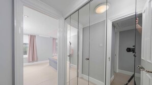 A room with a large mirror, a camera on a tripod, and a door leading to another room. - The Marylebone Hacienda (London)