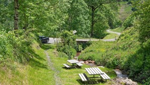 Ein Picknickbereich mit Bänken und einem Weg zu einer Brücke.