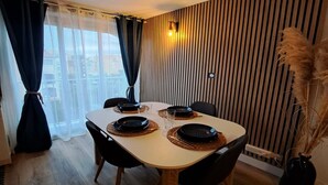 Een eetruimte met een ronde tafel, zwarte stoelen en zwarte borden.