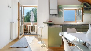 Cozinha moderna com vista, área de refeições e uma pequena varanda.