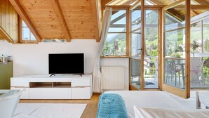Quarto com cama, televisão, janela e vista para o exterior.