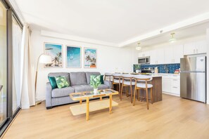 Ein modernes Wohnzimmer mit Sofa, Couchtisch und Essbereich.