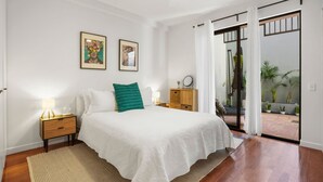 Una camera da letto con un letto, comodini, tende e vista sull'esterno.