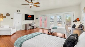A hotel room with a bed, a desk, a chair, a ceiling fan, and a view through the glass doors. - Private Hot Tub, Firepit & Duck Pond Near Canyon Lake + Whitewater Amphitheater (Canyon Lake)