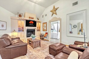 A living room with leather sofas, a fireplace, a television, and a star decoration on the wall. - Private Hot Tub, Firepit & Duck Pond Near Canyon Lake + Whitewater Amphitheater (Canyon Lake)