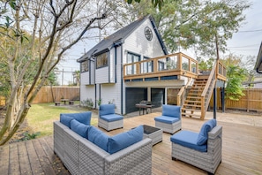 Ein Haus mit einer Terrasse, Sitzgelegenheiten im Freien und einem überdachten Bereich.