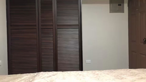 Un dormitorio con cama, armario y puerta.