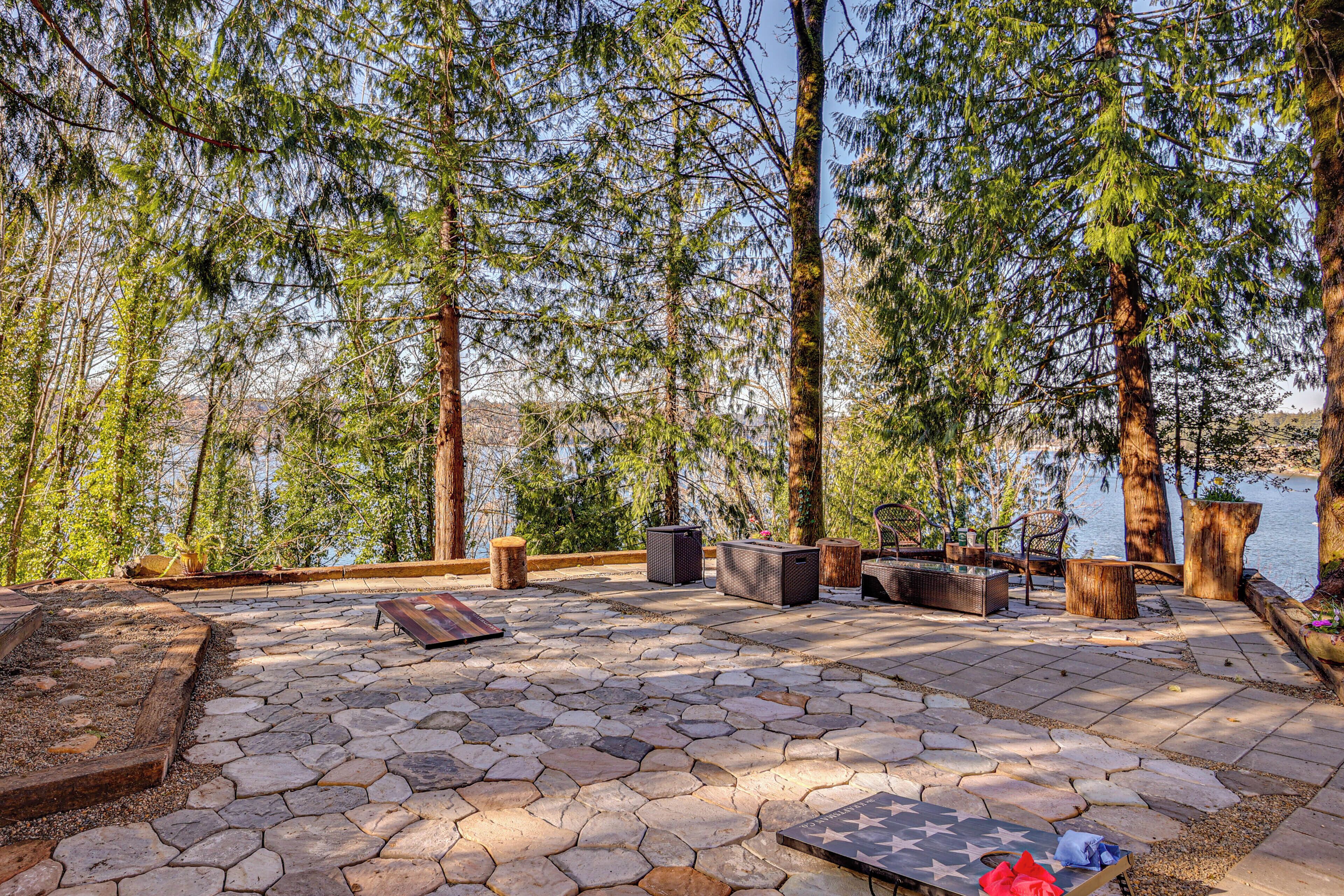 A patio area with stone flooring, outdoor furniture, and a view of a lake.