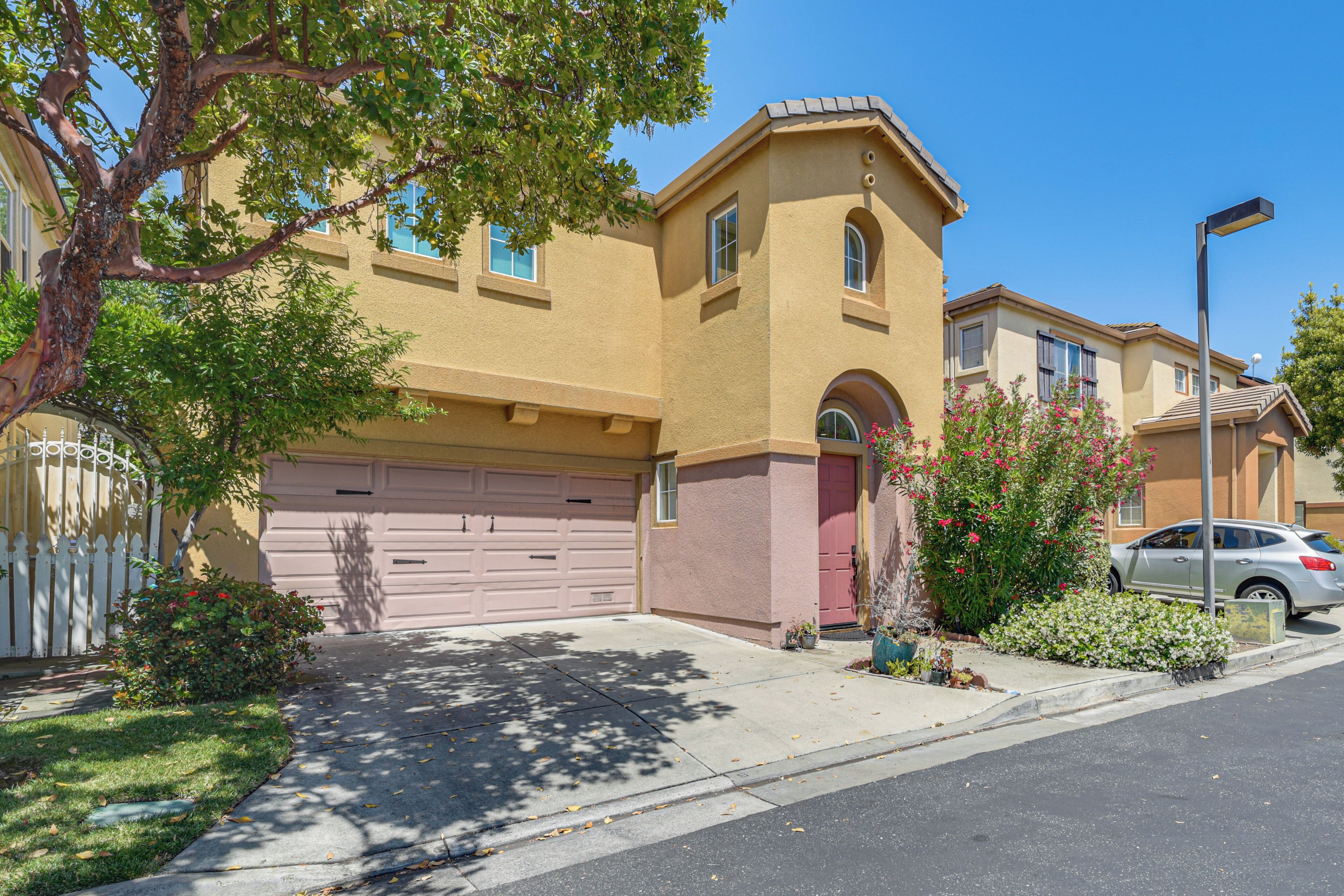 A residential building with a garage, a driveway, and a street view.