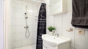 Kylpyhuone, jossa on suihku, pesuallas ja pyyheteline.