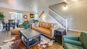 Ein geräumiges Wohnzimmer mit einer Couch, einem Couchtisch und einer Treppe, die in eine weitere Ebene führt.