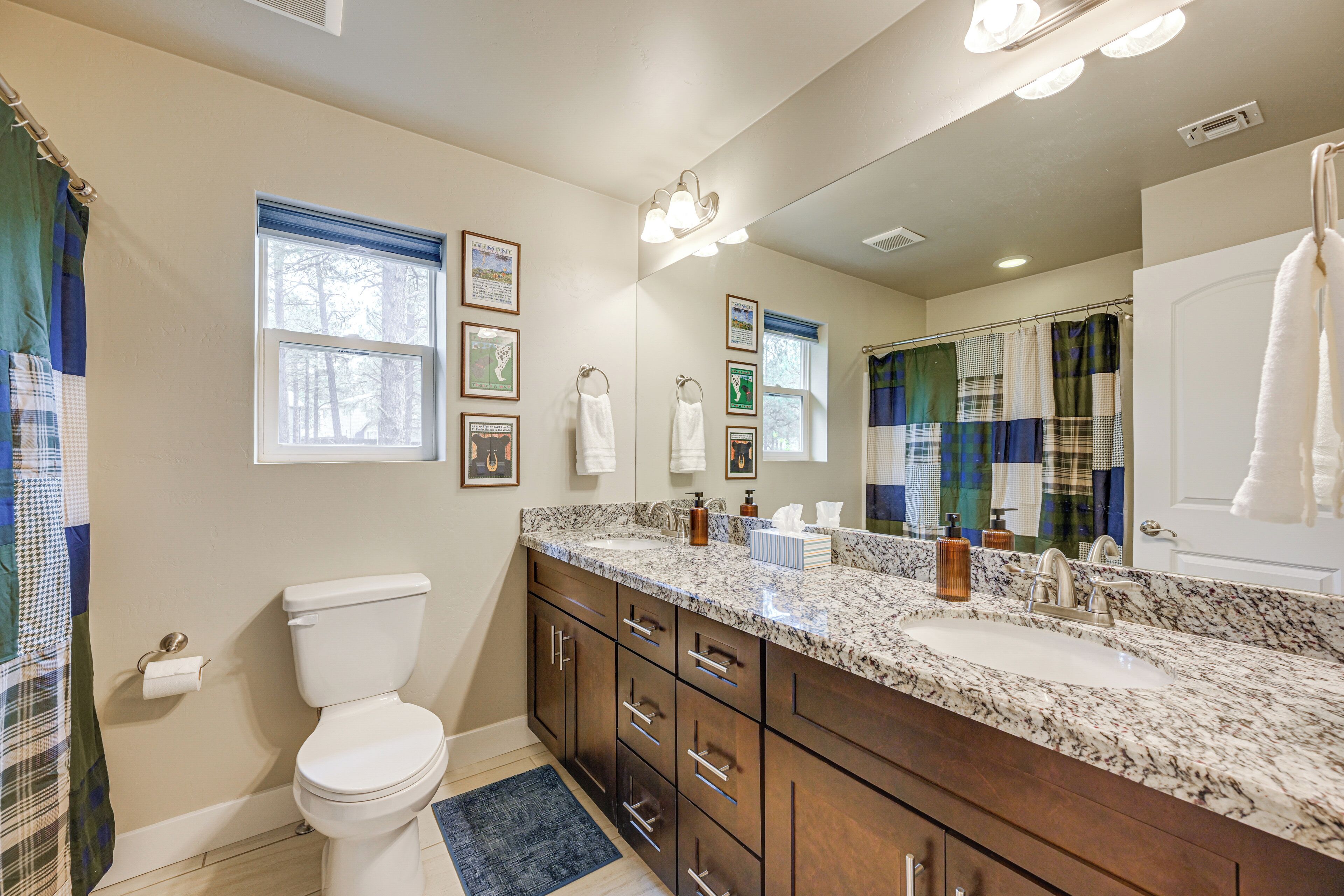A bathroom with a toilet, sink, mirror, and shower curtain.