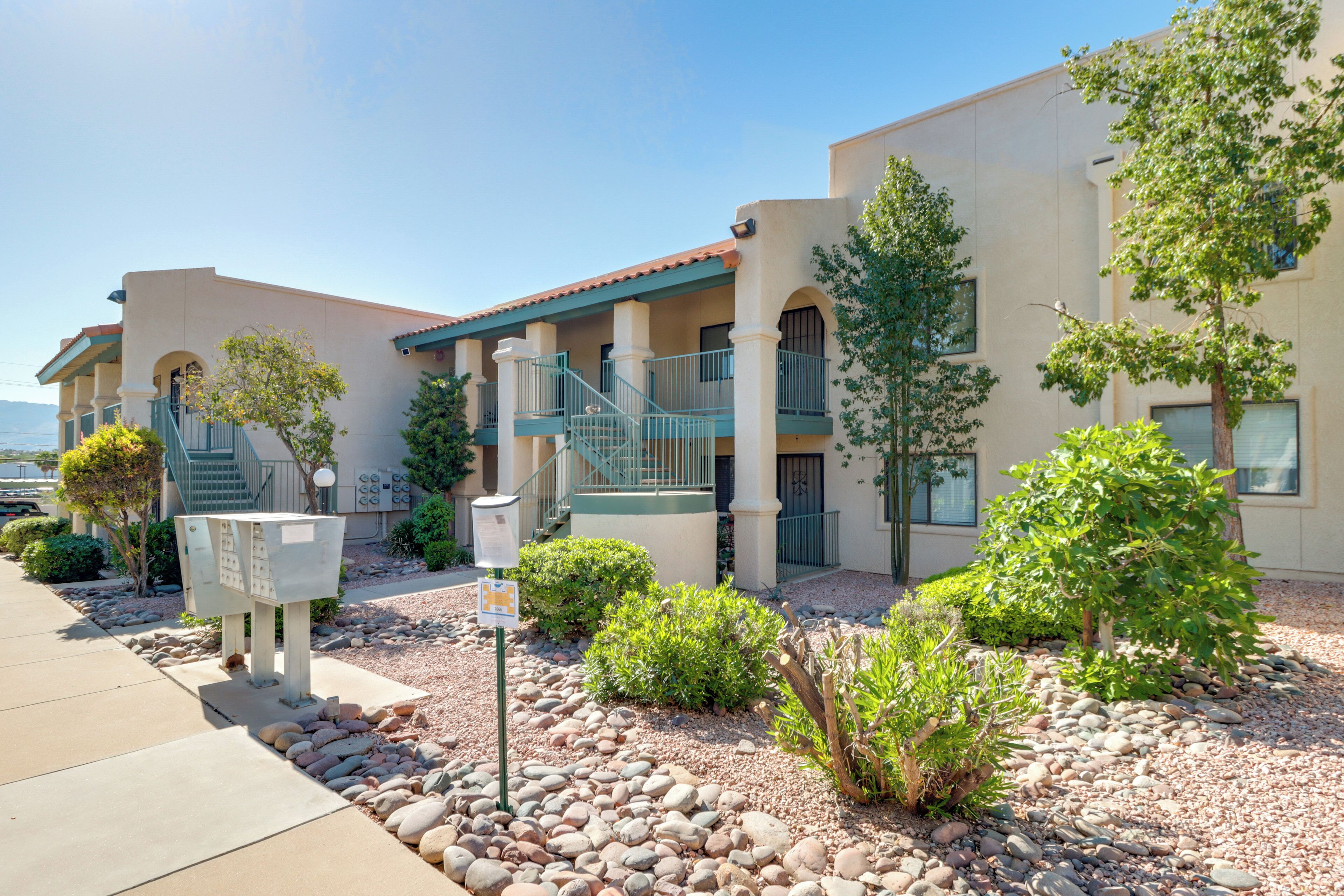 A building with a courtyard, outdoor seating, and a view of the ocean.