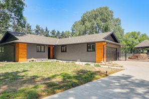 A modern two-story house with a brick exterior, large windows, and a front yard. - Great for Youth Sports Trips! Roomy Goddard Home (Goddard)