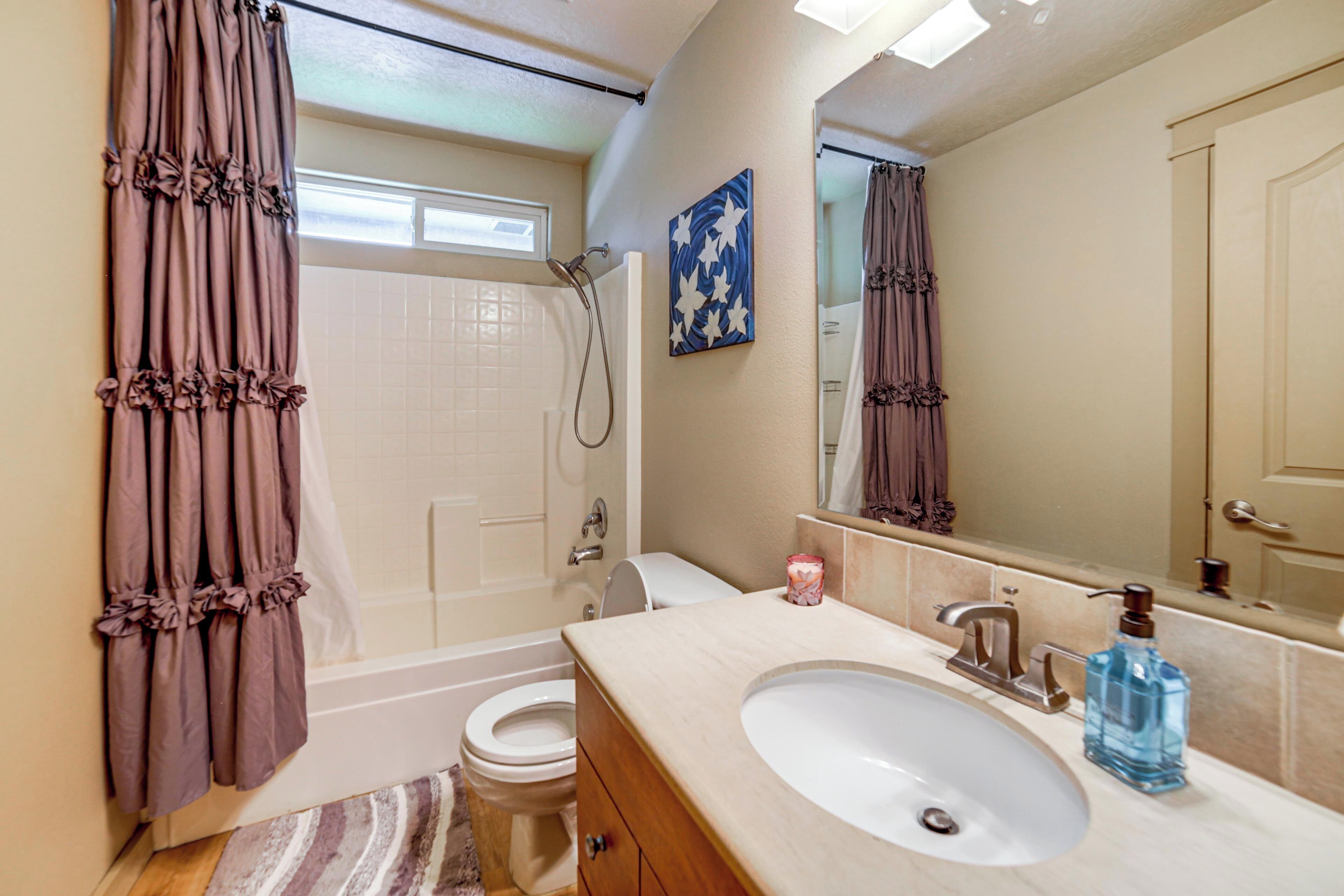 A bathroom with a bathtub, toilet, sink, and shower.
