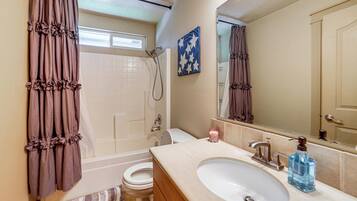 A bathroom with a bathtub, toilet, sink, and shower.
