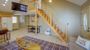 A spacious living area with a wooden staircase, a glass coffee table, and a cozy couch. - Lake & Dock Access! Waterfront Hot Springs Haven (Hot Springs)