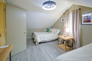 A bedroom with a bed, a bedside table with a lamp, a window with curtains, and a painting on the wall. - Lake & Dock Access! Waterfront Hot Springs Haven (Hot Springs)