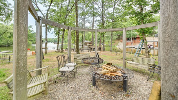 An outdoor seating area with a fire pit, benches, and a covered structure. - Lake & Dock Access! Waterfront Hot Springs Haven (Hot Springs)