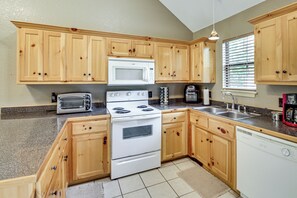 A kitchen with wooden cabinets, a microwave, a toaster, a stove, a dishwasher, and a window with blinds. - Lake & Dock Access! Waterfront Hot Springs Haven (Hot Springs)