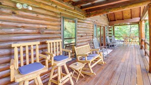 A log cabin with wooden furniture and a covered porch. - Game Room + Roof Deck: Ozarks Group Getaway! (Harrison)
