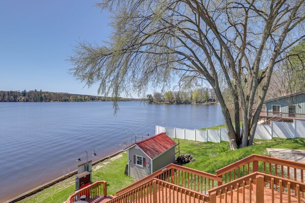 A lakeside property with a small shed, a wooden deck, and a view of the lake. - Waterfront Cabin w/ Boat Slip & Views in Croton! (Newaygo)