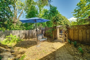 A backyard with a wooden fence, a bench, and a blue umbrella. - Charming Sonoma Wine Country Home Base w/ Extras (Cloverdale)