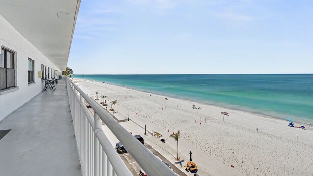 Ein Balkon mit Blick auf einen Strand und einen klaren Himmel.