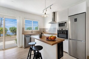 A modern kitchen with a wooden countertop, stainless steel appliances, and a view of the outdoors. - Loft the Ma-Air-BBQ (Adeje)