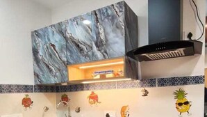Una cocina con armarios de mármol, estufa integrada y azulejos decorativos.