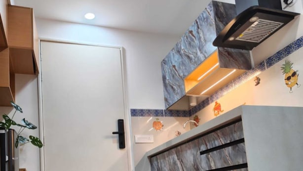 Una cocina moderna con salpicadero de mármol, horno empotrado y una pequeña isla.