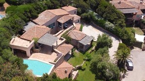 A residential area with multiple houses, a swimming pool, and a parking area. - Villa Hermes - Porto Cervo Center (Porto Cervo)