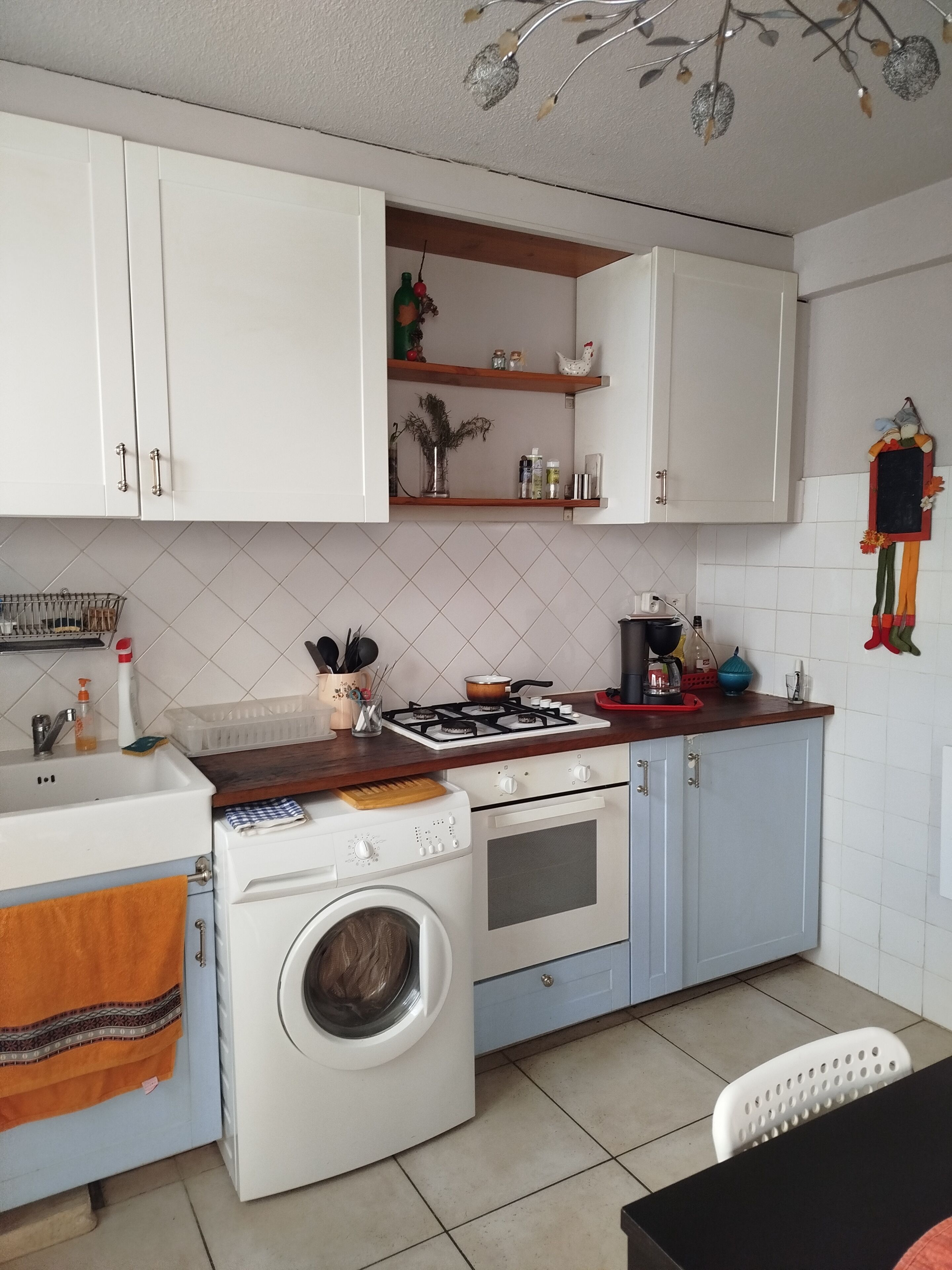 Una cocina compacta con lavadora, estufa y pileta.