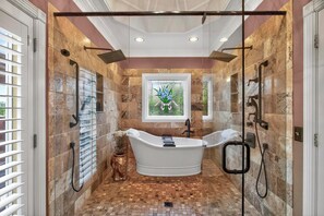 A bathroom with a freestanding bathtub, a glass shower enclosure, and a mosaic tile floor. - Luxury Estate with Hot Tub, 9 Hole Frisbee Golf, Fire Pit (Mount Juliet)