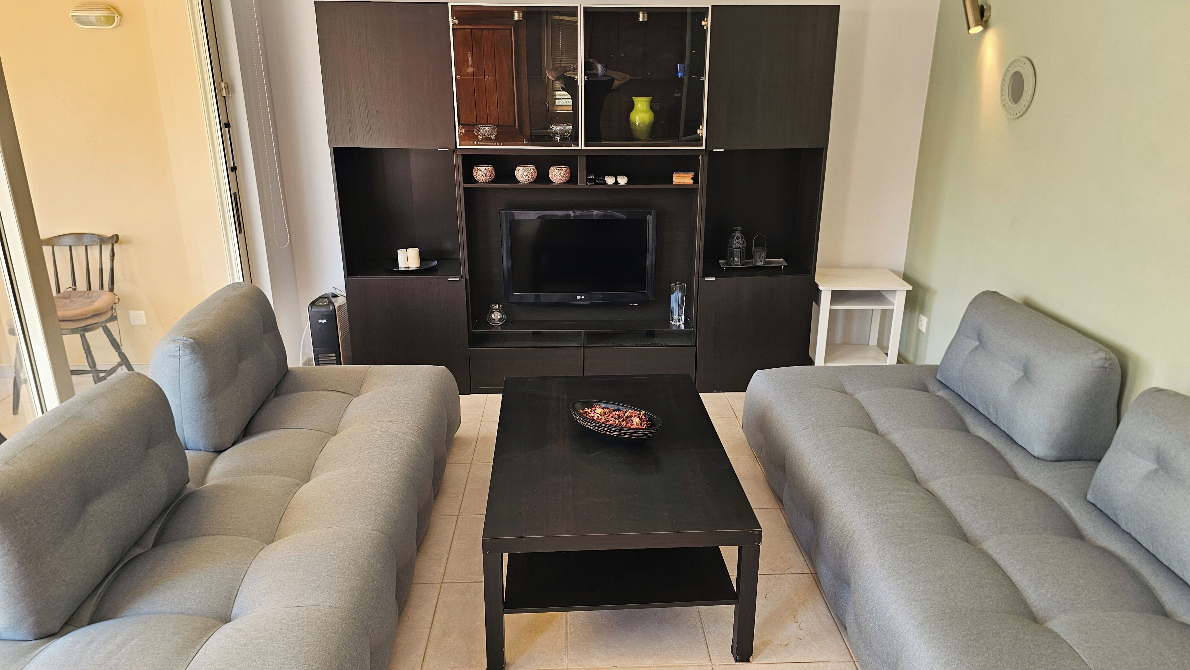 A living room with a sofa set, a coffee table, a TV, and a fireplace.